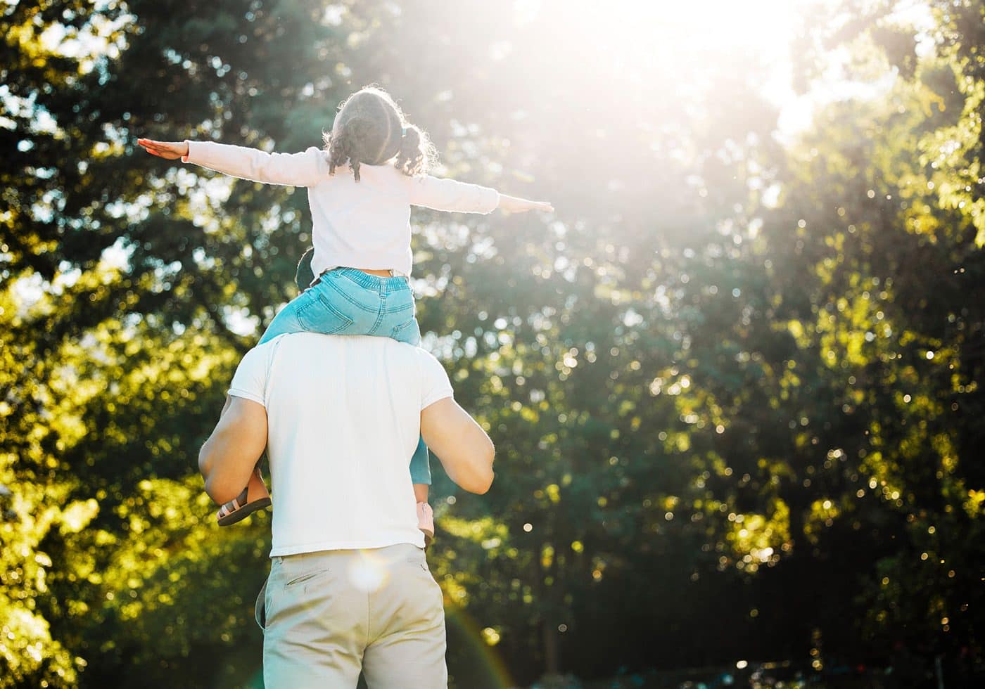 kid on dads shoulders outside