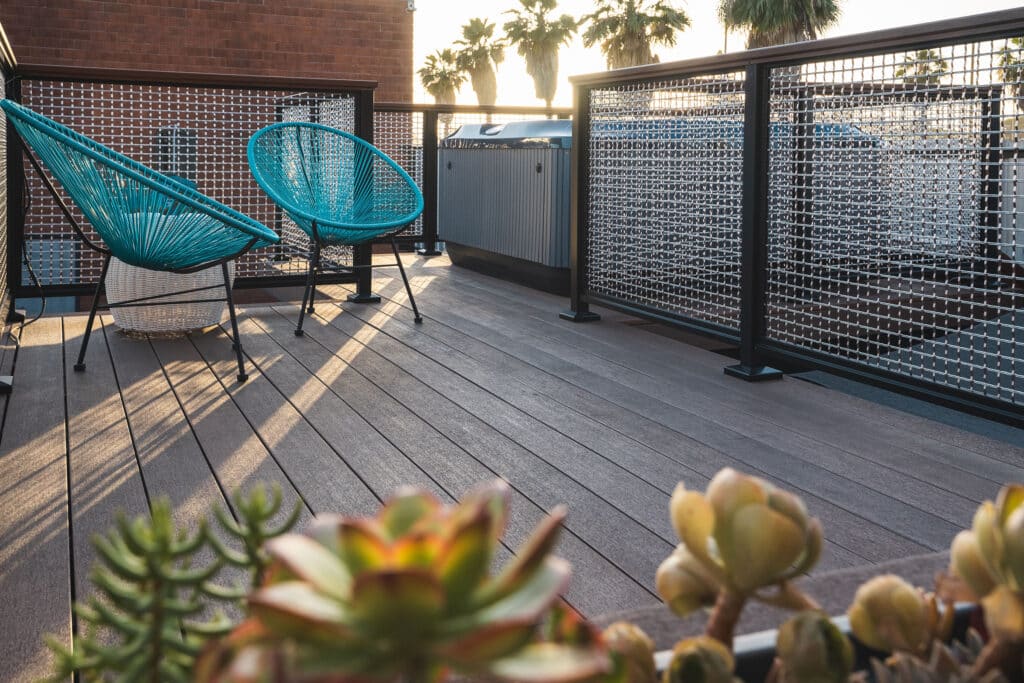 Container Bar in Long Beach, CA with a rooftop deck featuring DesignRail®Custom with Mesh, Laser and Cable infill, topped off with our wood grain powder coated top rail. Looks like a fun place to be after a long day at work!!